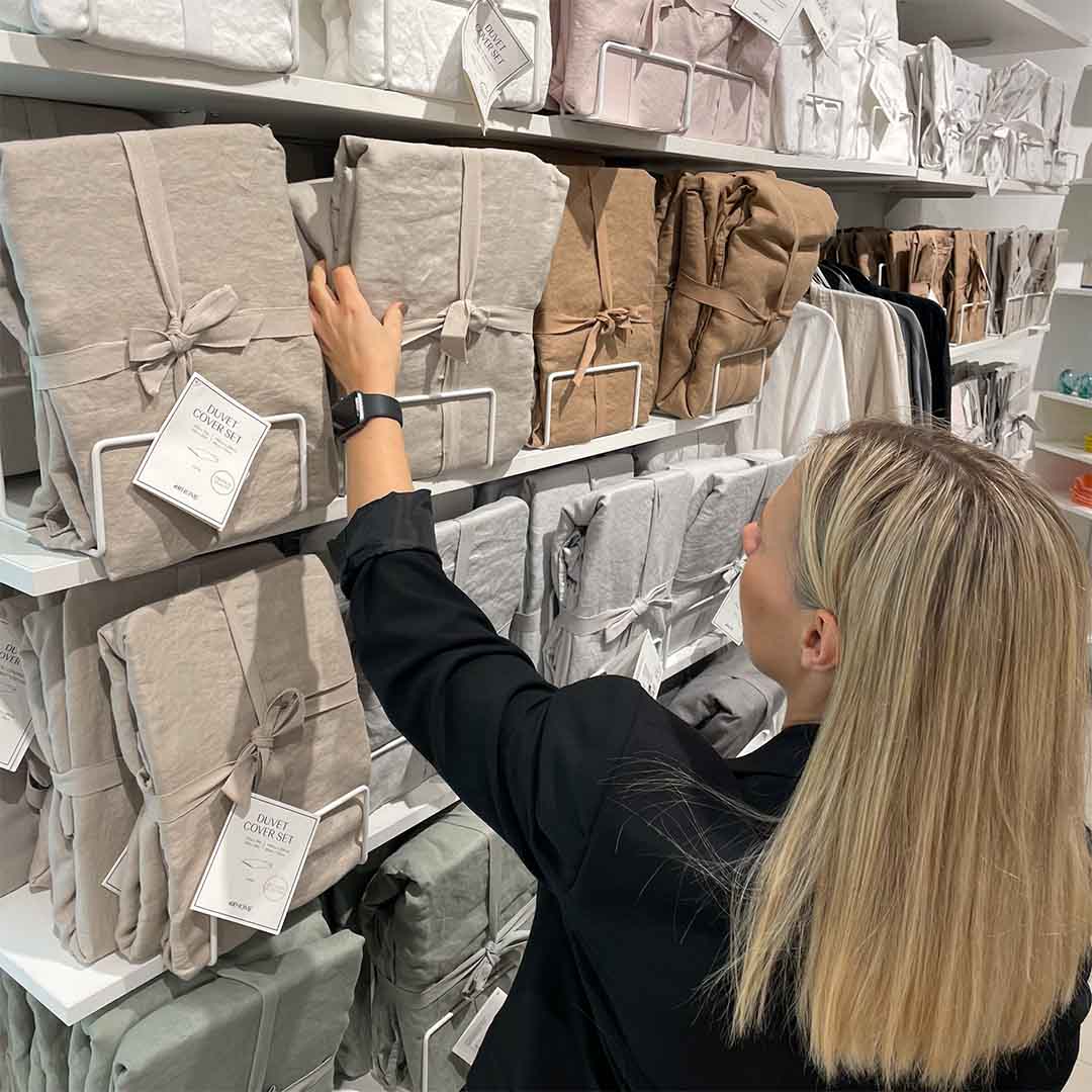 Kvinde shopper sengetøj i H&M store sengetøjsafdeling. 